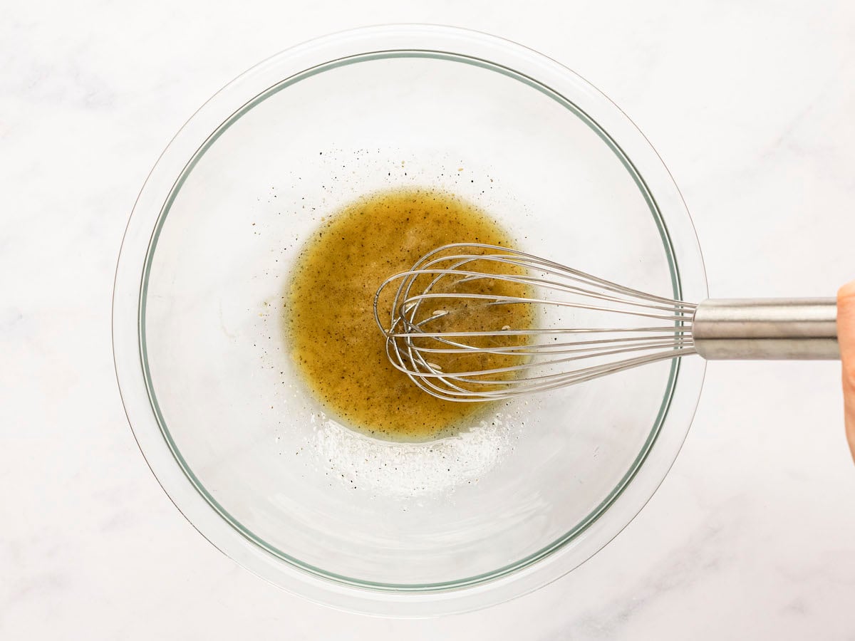 whisked dressing in bowl with whisk.