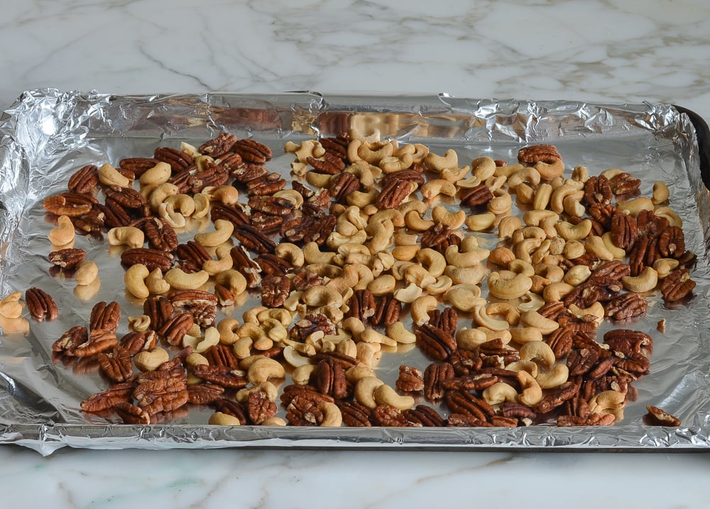 Nuts on a lined baking sheet.
