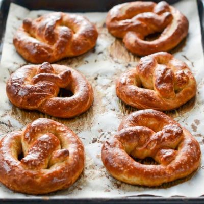 Soft pretzels on a lined baking sheet.
