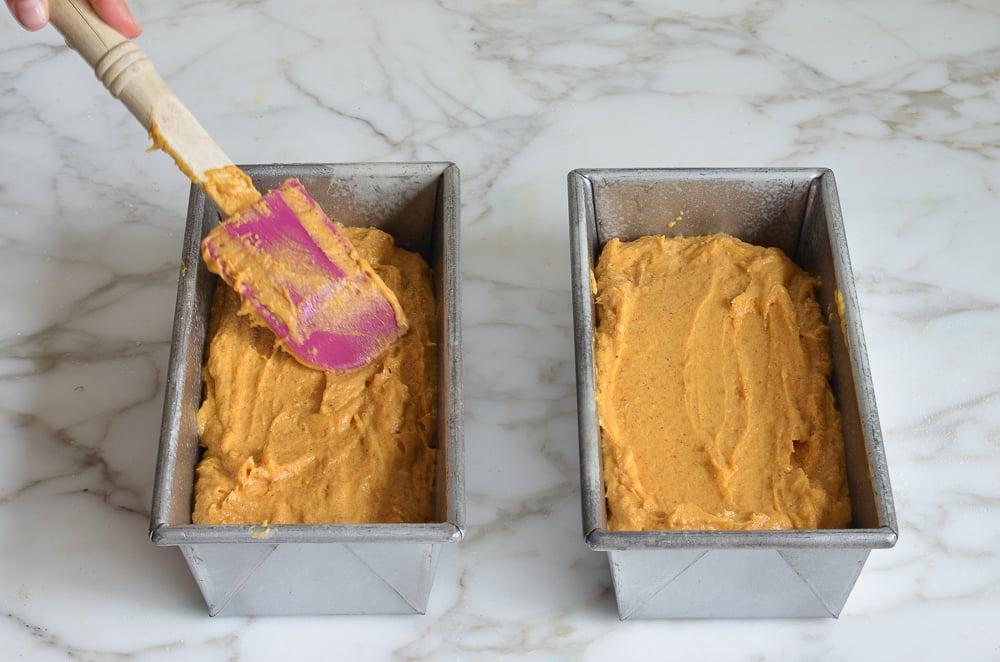 Two bread pans of pumpkin bread dough.