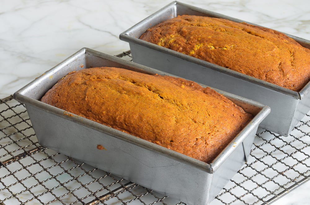 Two loaves of pumpkin bread in pan.s