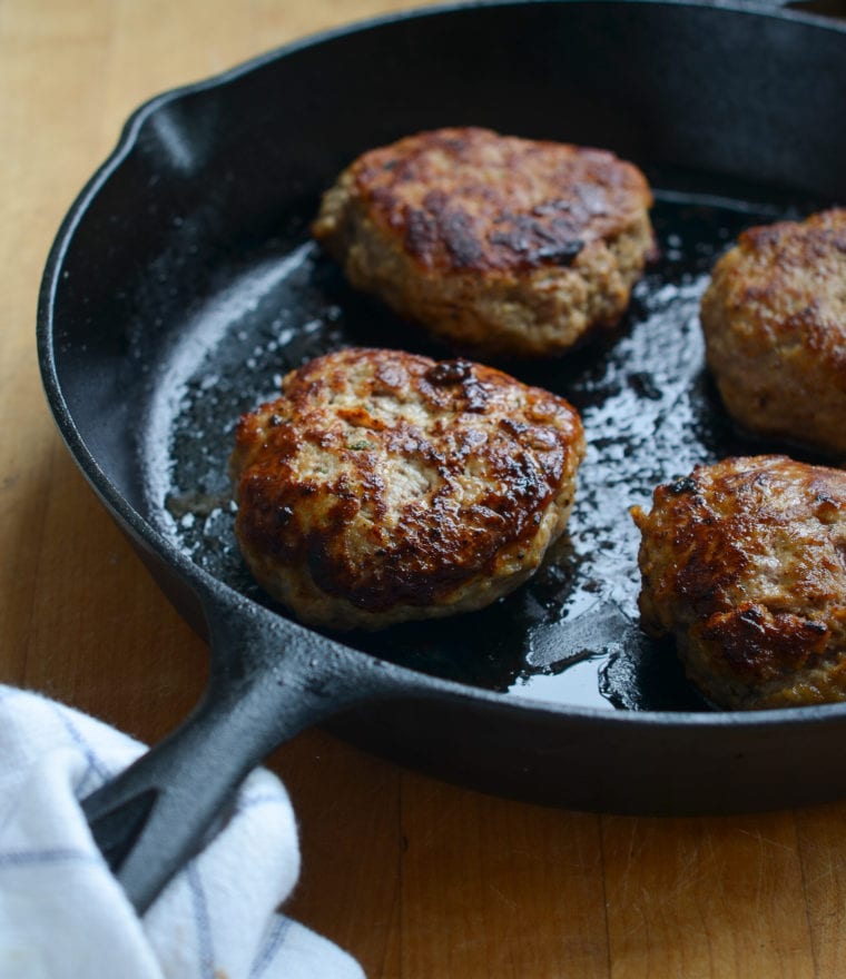 Turkey burger patties in a skillet.