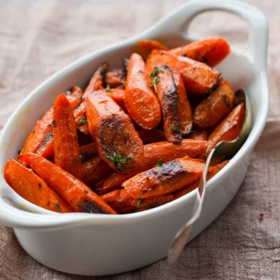 Roasted carrots with thyme in a baking dish.