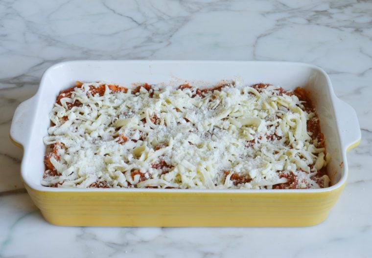 sprinkling cheese over top of squash