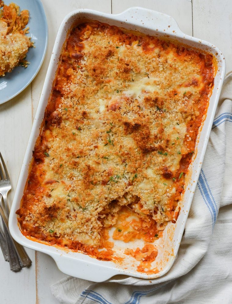 Cheesy baked spaghetti squash with marinara sauce in a baking dish.