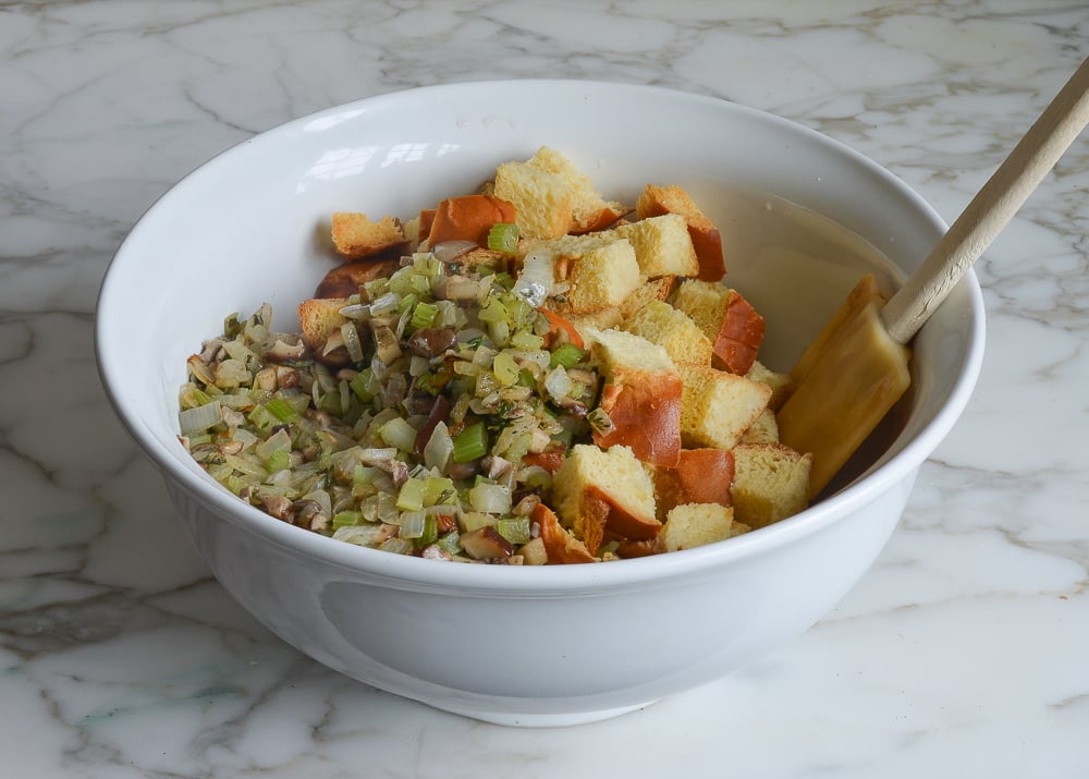 Toasted challah in a bowl with a mushroom mixture.