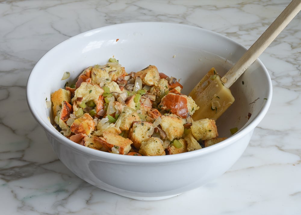 Spatula in a bowl with a challah and mushroom mixture.