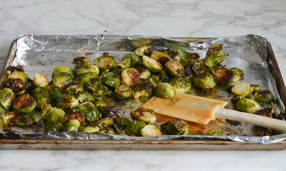 tossing roasted Brussels sprouts with balsamic and honey