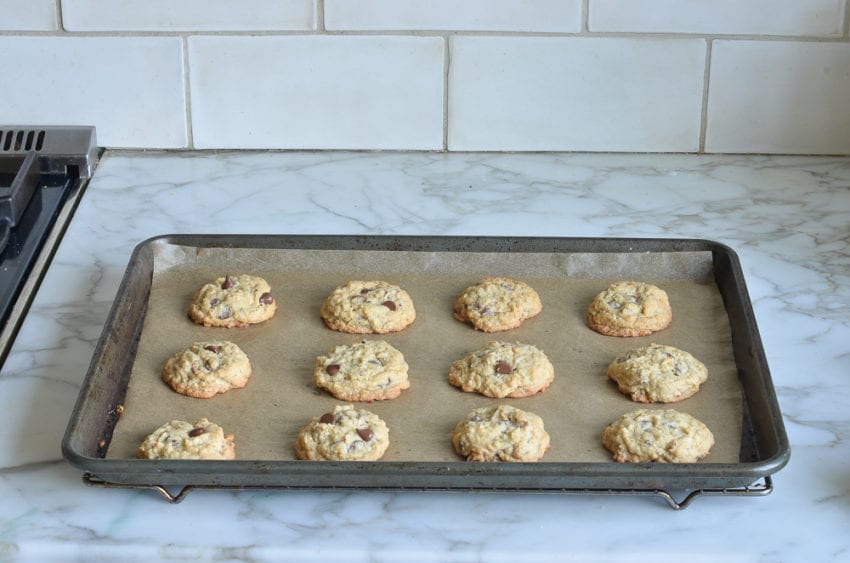 Chocolate chip cookies on a lined baking sheet.