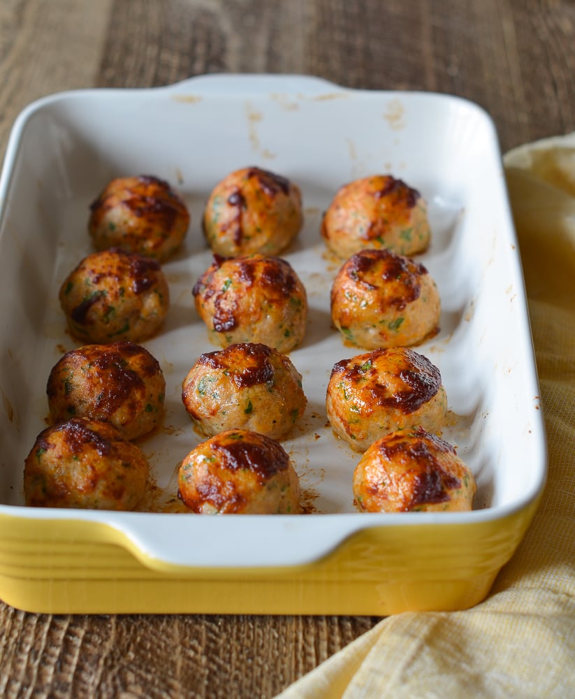 Chicken meatballs in a yellow baking dish.
