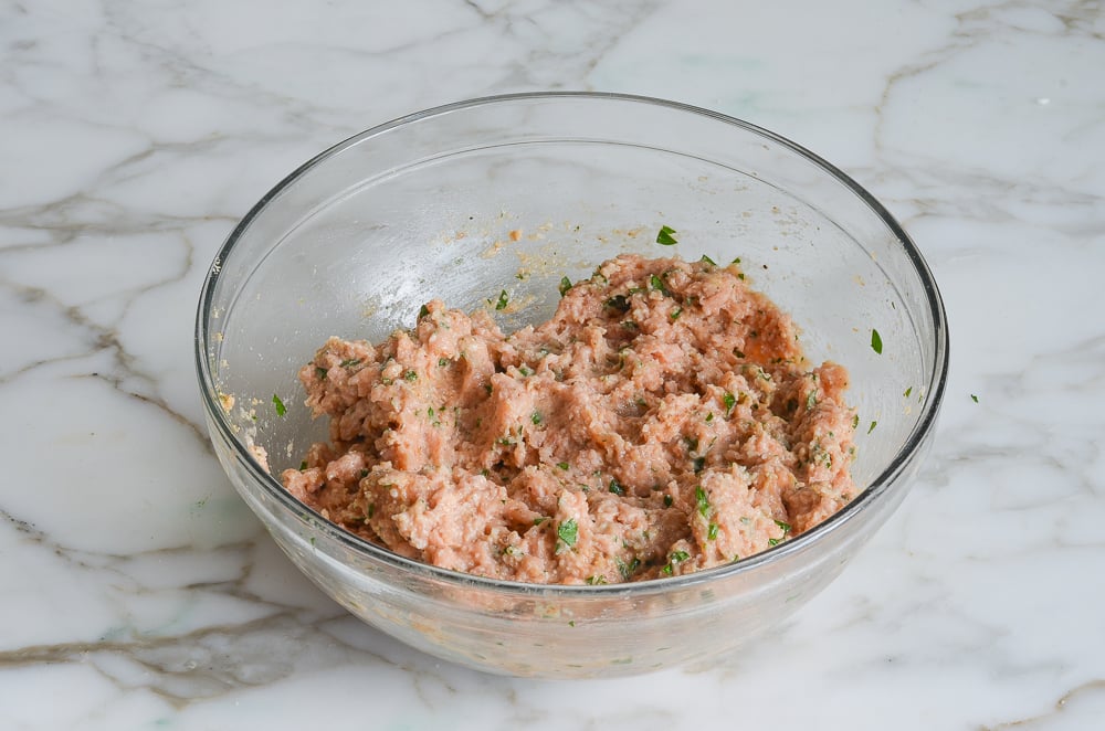 Bowl of ground meat with other ingredients.