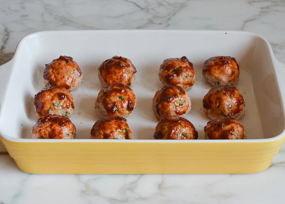 Chicken meatballs in a yellow baking dish.