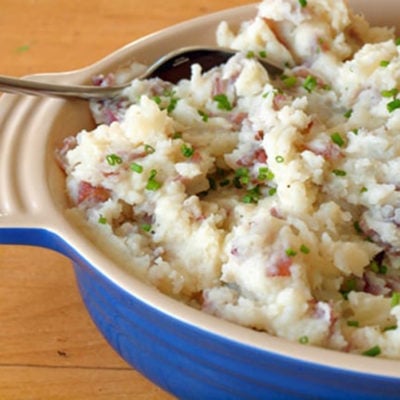 Spoon in a dish of parmesan smashed potatoes.