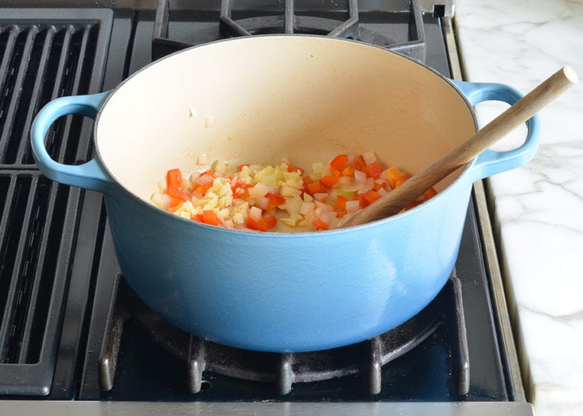 Cooked onions and red peppers in a Dutch oven.