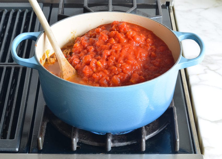 Tomatoes in a Dutch oven with a chicken mixture.