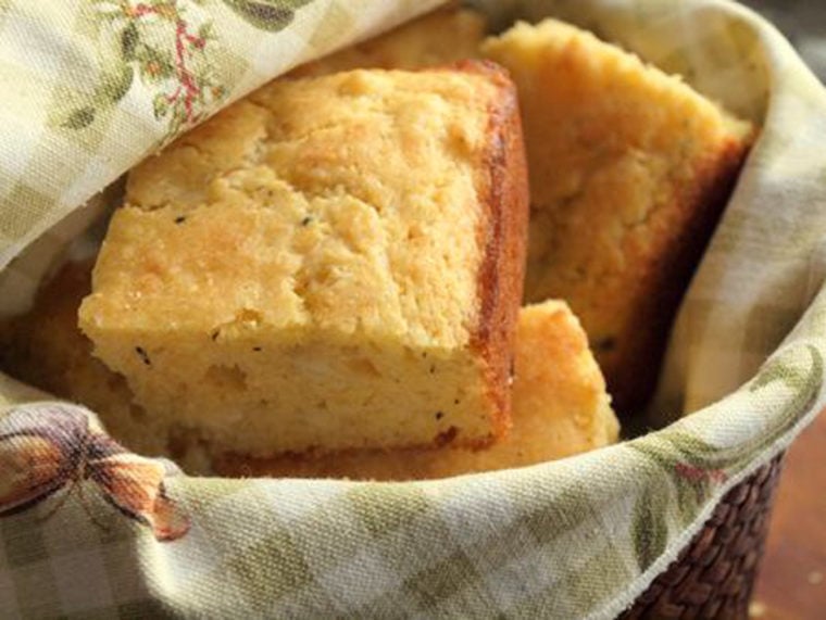 Pieces of savory cornbread with cheddar and thyme in a basket.