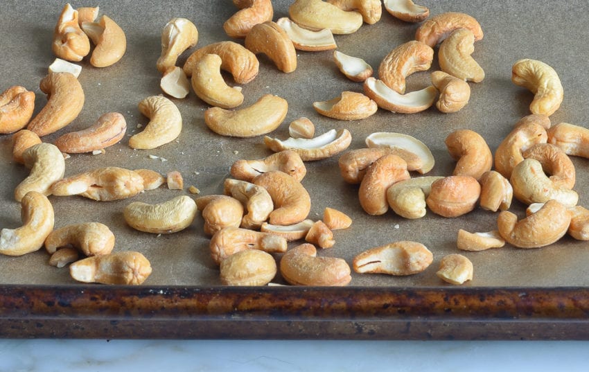 Cashews on a lined baking sheet.