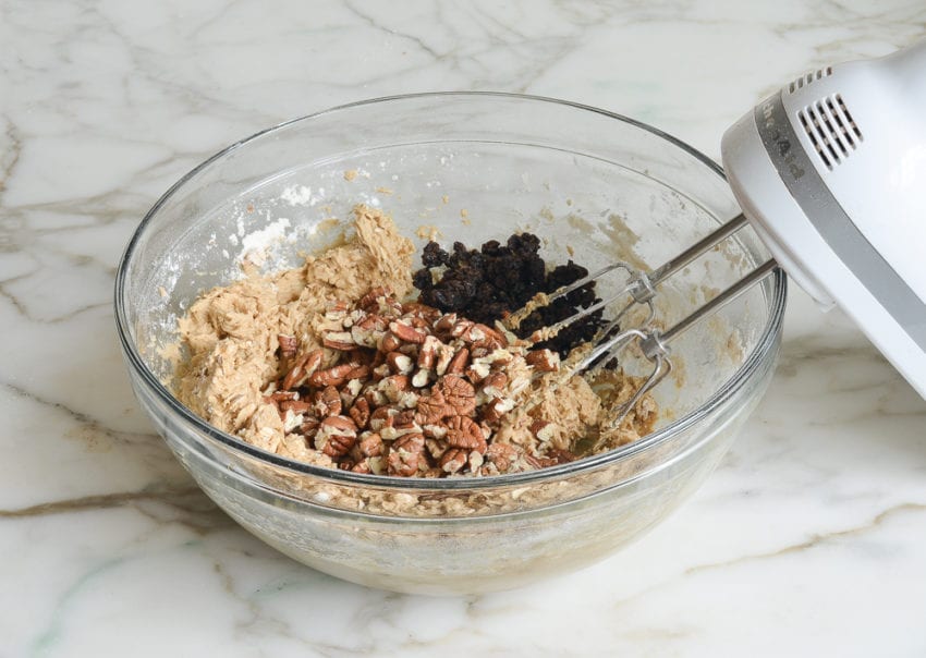 adding the pecans and raisins to the oatmeal cookie dough