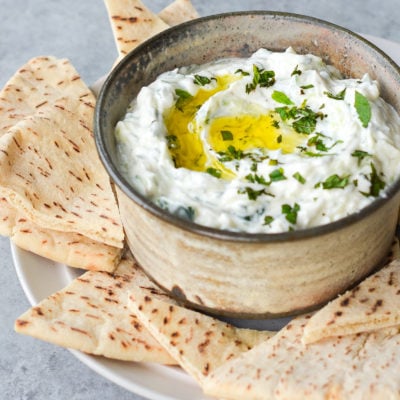 Tzatziki in a bowl with pitas.