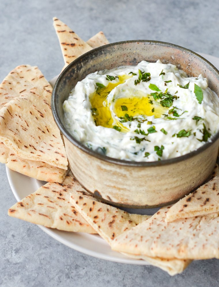 Tzatziki in a bowl with pitas.