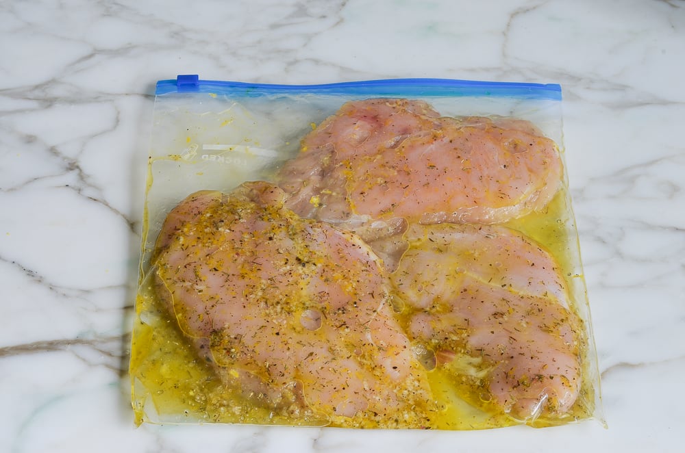 massaging marinade into chicken