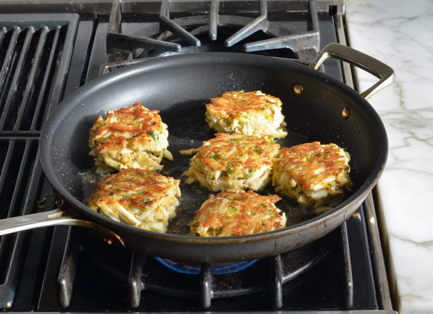 Crab cakes in a skillet.