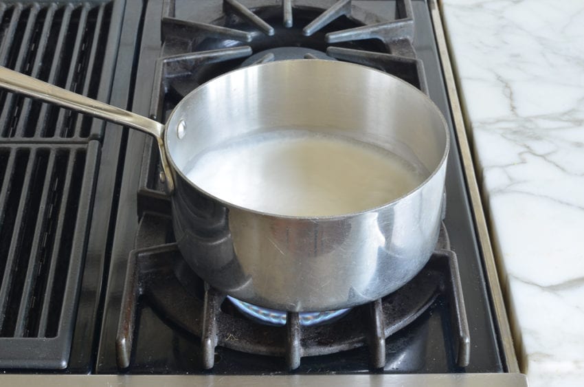 Malibu and milk mixture in a pan on a stovetop.