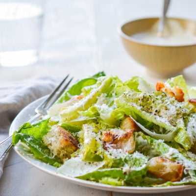 Fork on a plate with a Caesar salad.