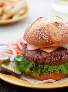 Steakhouse burger on a plate with burger toppings.