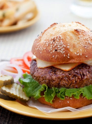 Steakhouse burger on a plate with burger toppings.