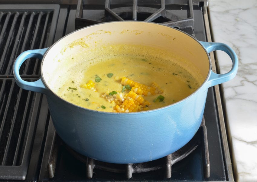 Corn kernels in a Dutch oven of soup.