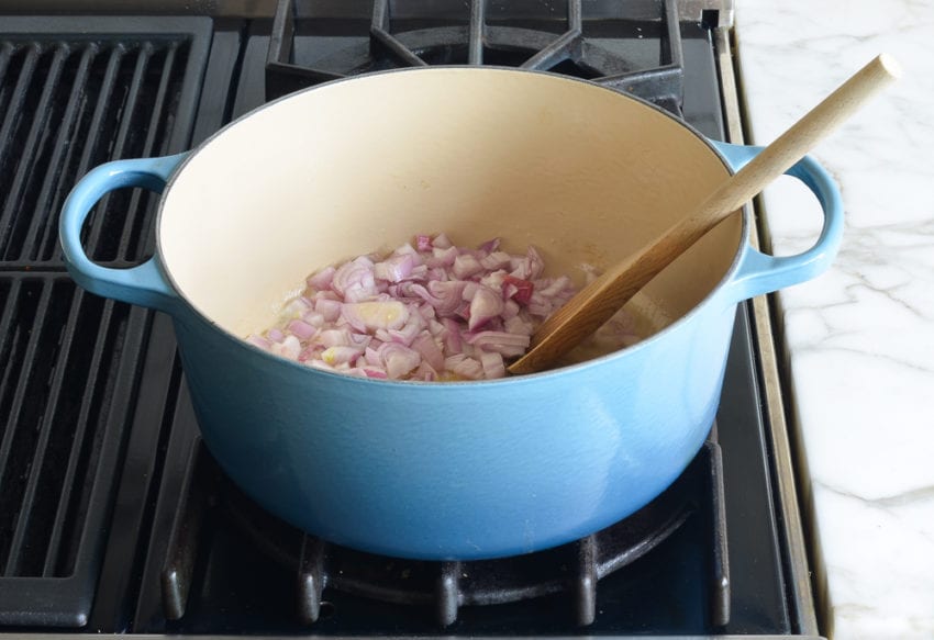 Red onions in a Dutch oven.