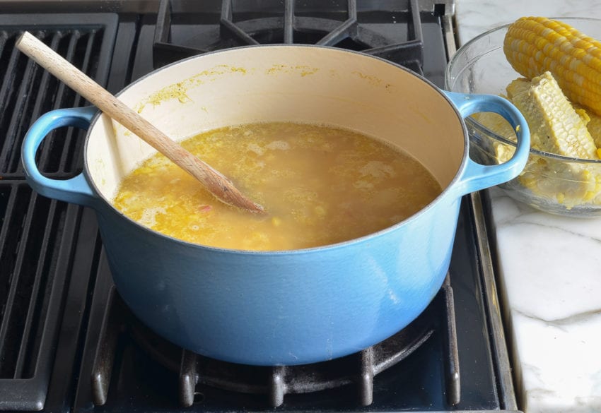 Wooden spoon in a Dutch oven of soup.