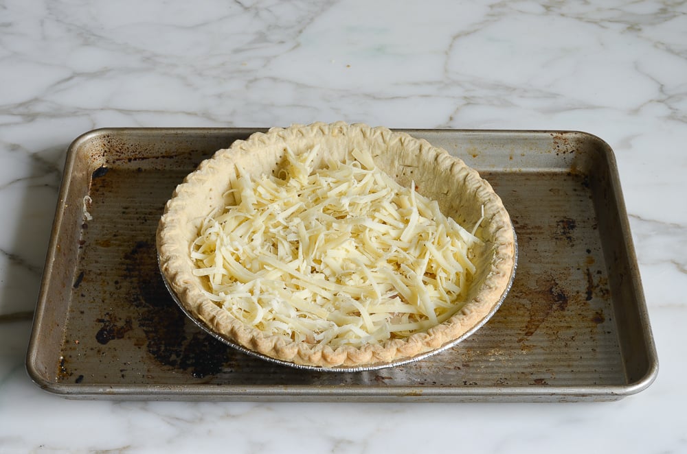 layering shredded cheese in crust