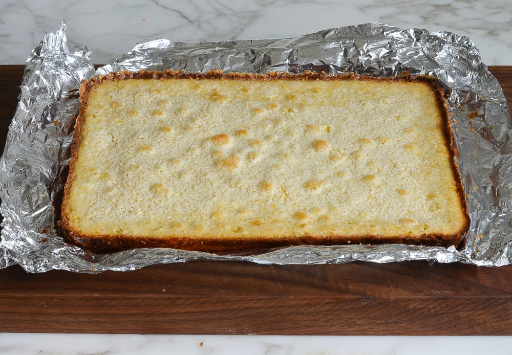 Lemon bars transferred to cutting board and foil underneath.