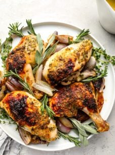 Roast chicken with herb butter on platter.