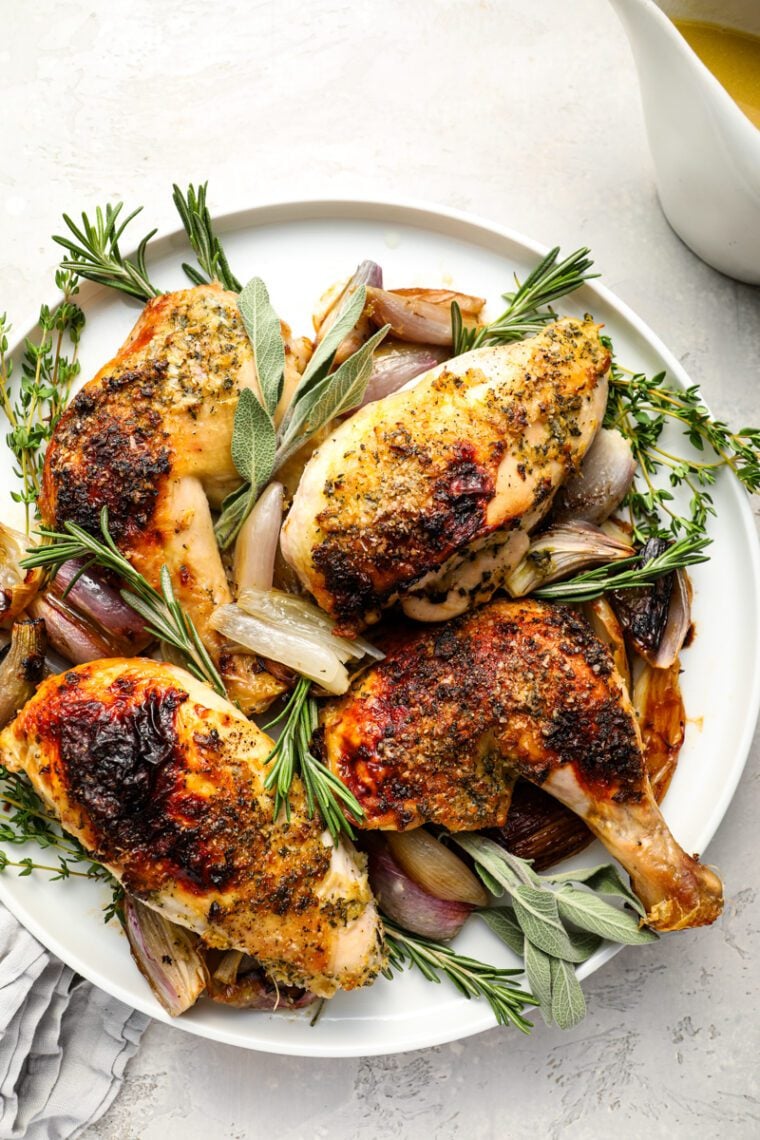 Roast chicken with herb butter on platter.