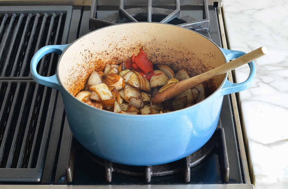 Tomato paste in a Dutch oven with onions.