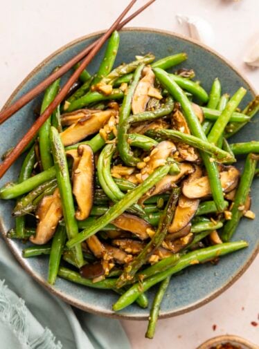 Szechuan green beans in bowl with chopsticks.