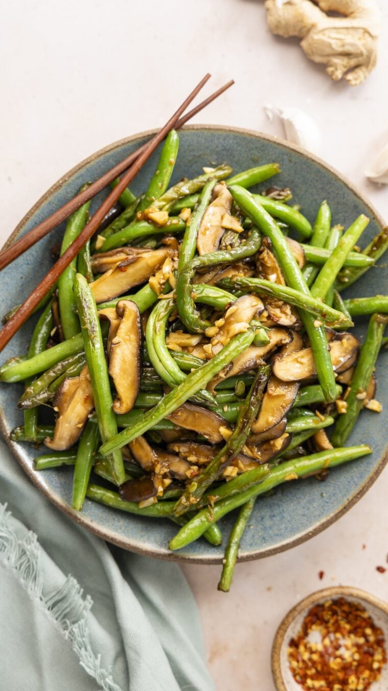 Szechuan green beans in bowl with chopsticks.