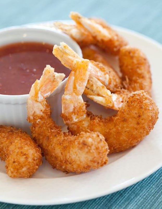 White plate of coconut shrimp with dip.