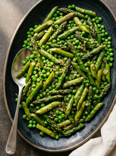 Sautéed asparagus and peas on serving platter.