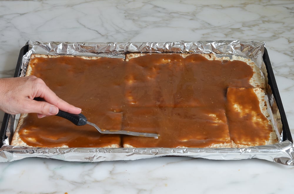spreading toffee over matzo