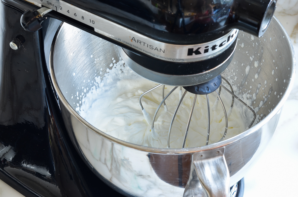 Whipped cream being made in a stand mixer.