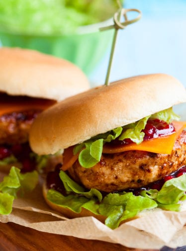 Two turkey burgers on a cutting board.