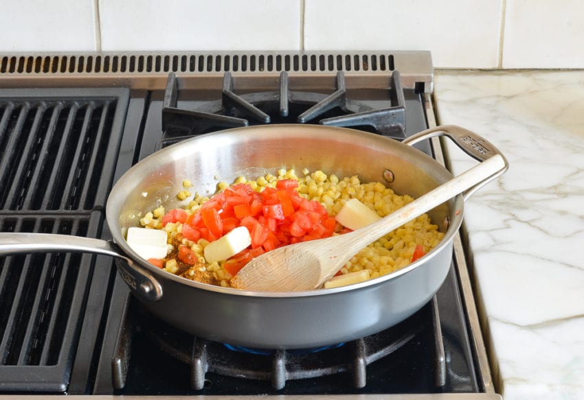 cooked corn, tomatoes, and butter in skillet