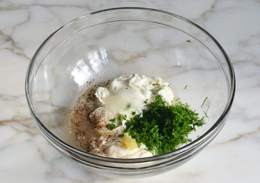 Unmixed dressing ingredients in a glass bowl.