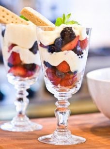 two lemon berry parfaits on wooden board.