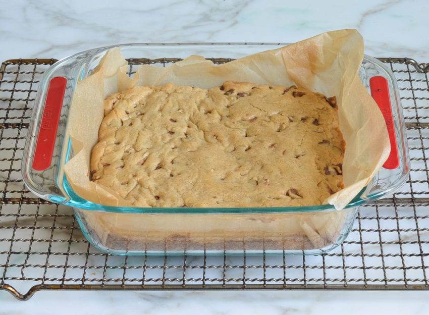 Lined baking dish of baked blondies.