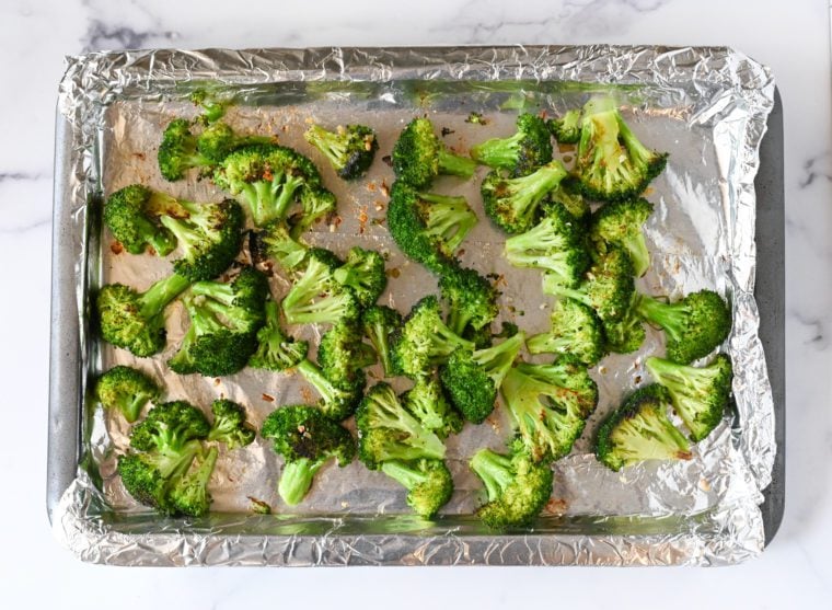 Lined baking sheet of roasted broccoli.